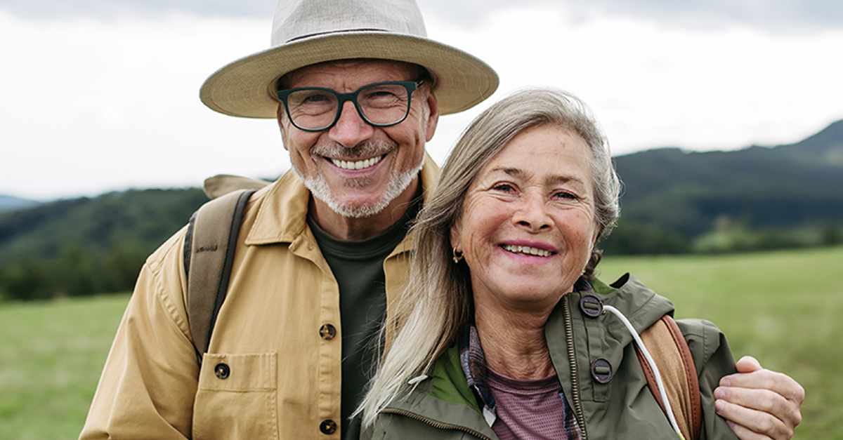 Older couple on group trip in autumn nature.